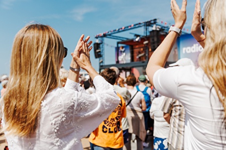 People applaud for stage on the sea dike