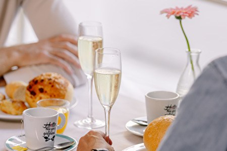 Two people at a table with champagne and coffee