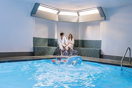 couple on relax sofa, children in the pool