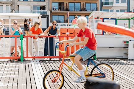Child on a crazy bike while ladies are watching